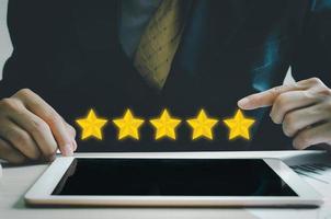concepto de cliente excelente servicio para satisfacción calificación de cinco estrellas con pantalla táctil de hombre de negocios en tableta. comentarios y comentarios positivos de los clientes.