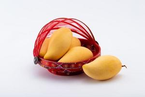 Fresh tropical golden Mango fruits in red basket. photo