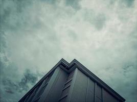 Photo of a very tall white building and a cloudy sky with a lot of clouds with a monochrome concept. photos that are suitable as wallpapers with negative space