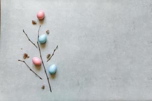 Happy Easter concept. Preparation for holiday. Colorful decorated easter eggs spring branches on concrete stone grey background. Simple minimalism flat lay top view copy space. photo