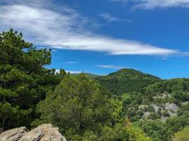 blue sky white clouds on the hill, mountain with a trees view. photo