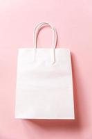 Simply minimal design shopping bag isolated on pink pastel background. Online or mall shopping shopaholic concept. Black friday Christmas season sale. Flat lay top view copy space, mock up photo