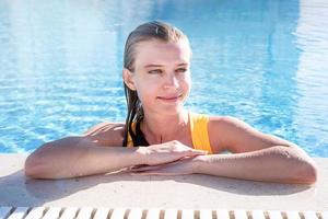 Young beautiful woman having fun swimming in the pool in summer