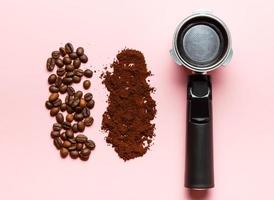 Espresso machine filter holder, ground coffee and coffee beans on pink background. photo