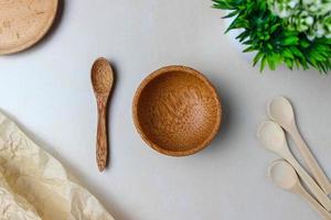 Wooden utensils on the kitchen table. Round wooden plates, a wooden spoons, a green plant. The concept of serving, cooking, cooking, interior details. Top view photo
