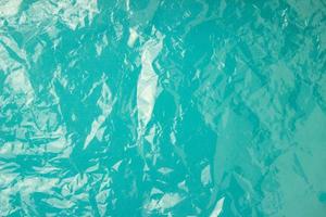 The texture of the plastic bag on a blue background. Crumpled transparent bag, plastic photo