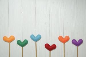 Top view colorful heart shape on white wooden plank background. For valentine day concept. photo