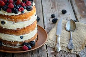 Victoria sponge cake with whipped cream and berries on top photo