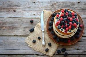 Victoria sponge cake with whipped cream and berries on top photo