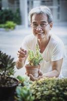 Sonrisa dientuda de un anciano asiático con cara de felicidad en el jardín de su casa foto