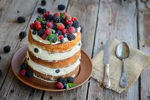 Victoria sponge cake with whipped cream and berries on top photo