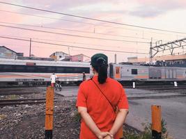 Bekasi, West Java, Indonesia, February 19th 2022. A woman standing waiting for the train to pass photo