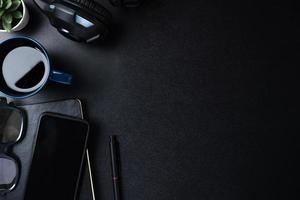 top view working desk with keyboard headphone and mobile phone on black table background photo