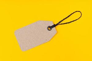 Blank cardboard Tag isolated on yellow background. Template mock up photo