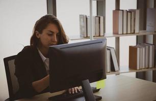 joven empresaria que trabaja en la computadora en la oficina foto