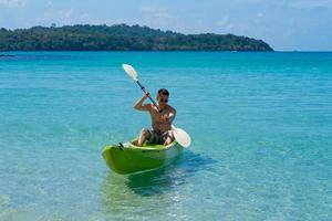 Asian Man kayaking in Blue Sea photo