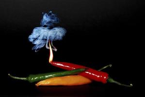 pepper with flame and smoke on black photo