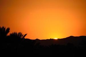 puesta de sol con montaña foto