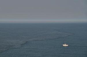 sailboat in the sea with wave photo