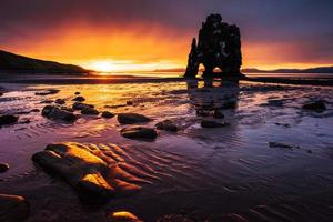 hvitserkur 15 m de altura. es una roca espectacular en el mar en la costa norte de islandia. esta foto se refleja en el agua después de la puesta de sol de medianoche.