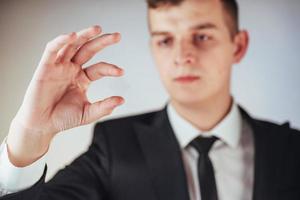 Young businessman in a suit shows his hand photo