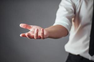 Young businessman showing empty hands, ready to fill with your design photo