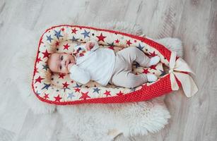 Photo charming newborn baby in a red cradle