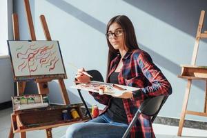 Pretty Pretty Girl artist paints on canvas painting on the easel. photo