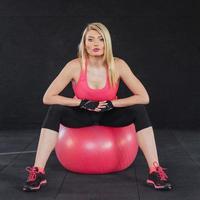 Young attractive slim woman in sportswear, doing fitness exercise ball. photo