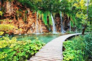 Waterfalls in national park falling into turquoise lake. Plitvice, Croatia photo