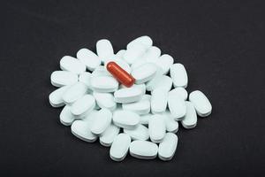 tabletas blancas médicas o suplementos para el tratamiento y la atención médica en un fondo negro foto