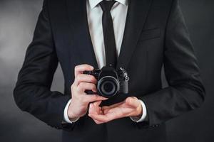 man holding black digital camera. In the studio photo