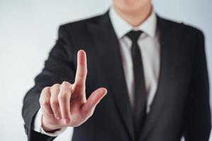 Businessman hand pointing on empty space on black background photo