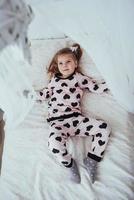 Child in soft warm pajama playing in bed photo