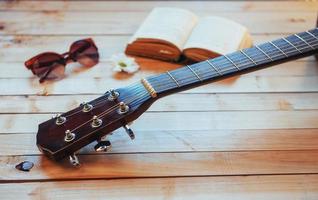 Close up classical guitar head with glasses and book photo