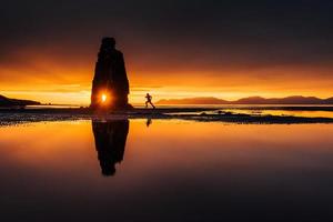 hvitserkur 15 m de altura. es una roca espectacular en el mar en la costa norte de islandia. esta foto se refleja en el agua después de la puesta de sol de medianoche.