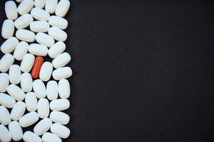 Medical colorful pills, capsules or supplements for the treatment and health care on a black background photo