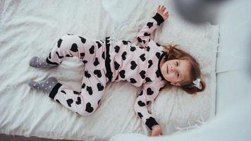 Child in soft warm pajama playing in bed photo