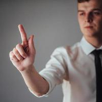 Businessman hand pointing on empty space on black background in the studio photo