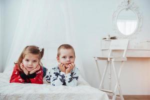 niño en pijama suave y cálido jugando en la cama foto