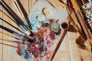 la paleta del artista. pinturas al óleo de colores sobre una paleta sobre una mesa.