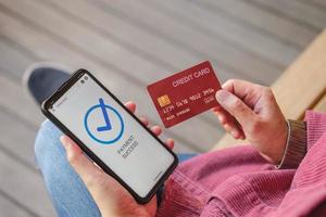 mujer asiática usa pago con tarjeta de crédito sin contacto en la aplicación de compras móviles foto