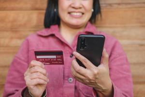 Asian woman use credit card pay contactless on mobile shopping app photo
