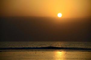 sunrise with waves on the sea photo