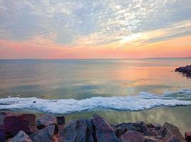 cielo del atardecer sobre el mar por la noche con nubes coloridas foto