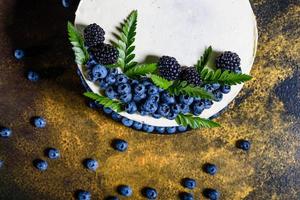 Beautiful delicious cake with blueberries and white cream photo