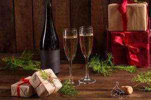 mesa navideña con copas y una botella de vino de champán foto