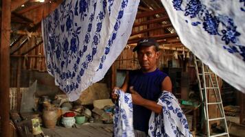 actividad de hacer batik, crear y diseñar telas blancas usando canto y cera golpeando la tela, pekalongan, indonesia, 7 de marzo de 2020 foto