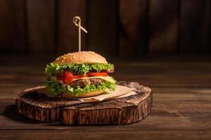 Delicious fresh juicy burger with beef cutlet, cheese, tomatoes and onions photo