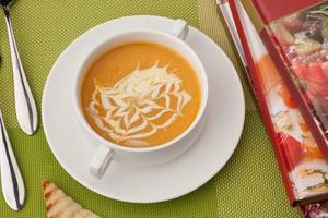 soup and a book on a green tablecloth photo